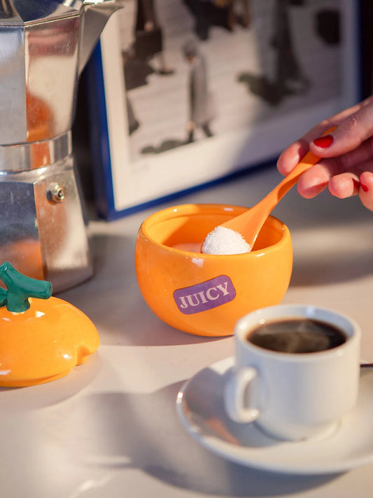 Orangefarbene Keramik-Zuckerdose von DOIY Design neben einer Kaffeetasse