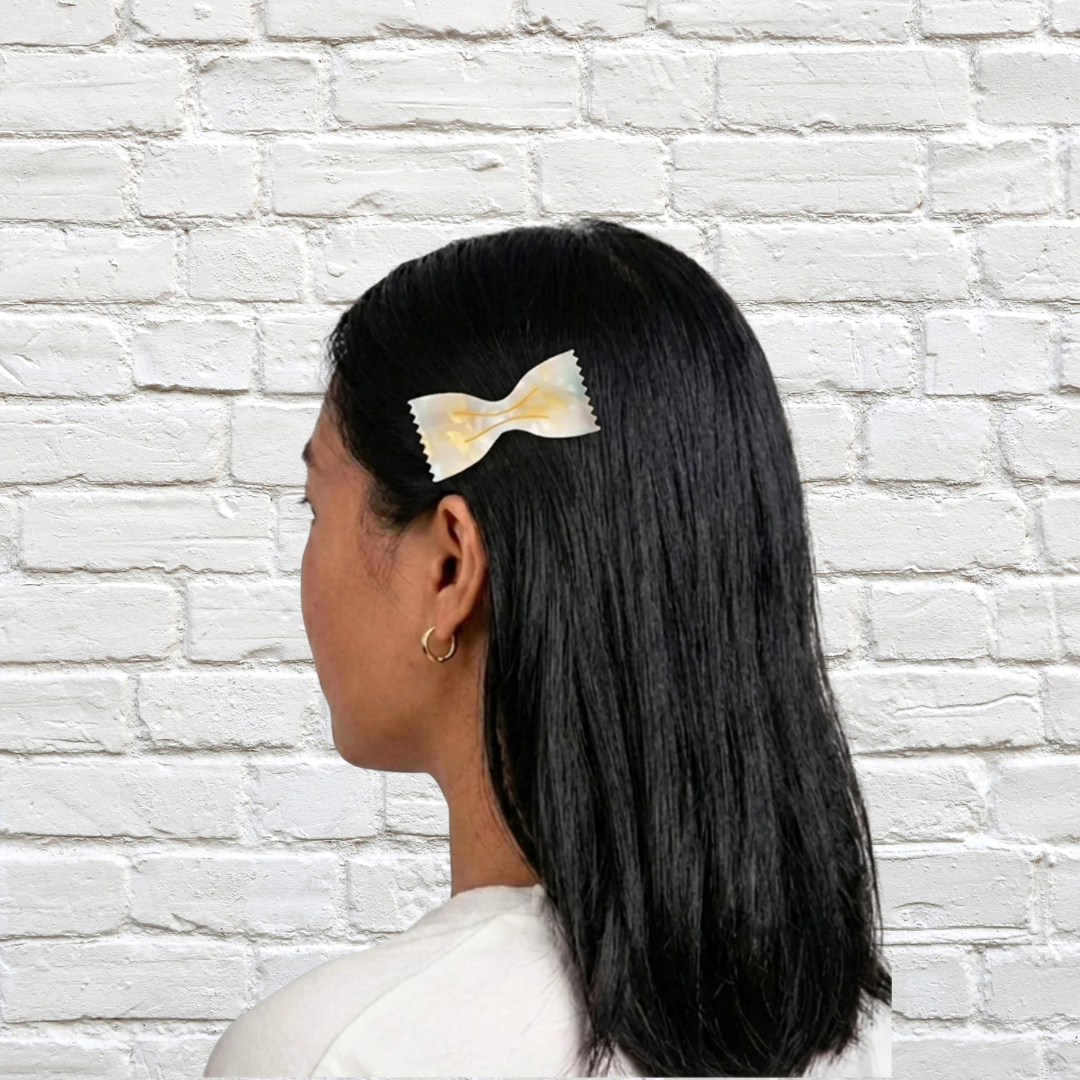 Cremefarbene Haarspange von Eat My Socks in SFarfalleform im schwarzen Haar