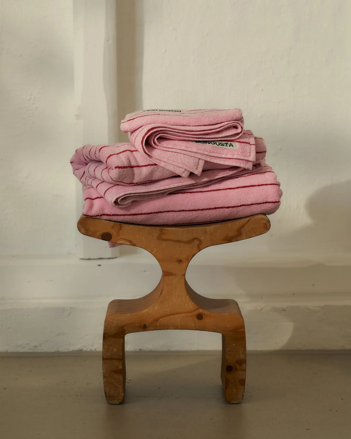 Rosa Naram Handtücher von Bongusta auf einem Holzhocker
