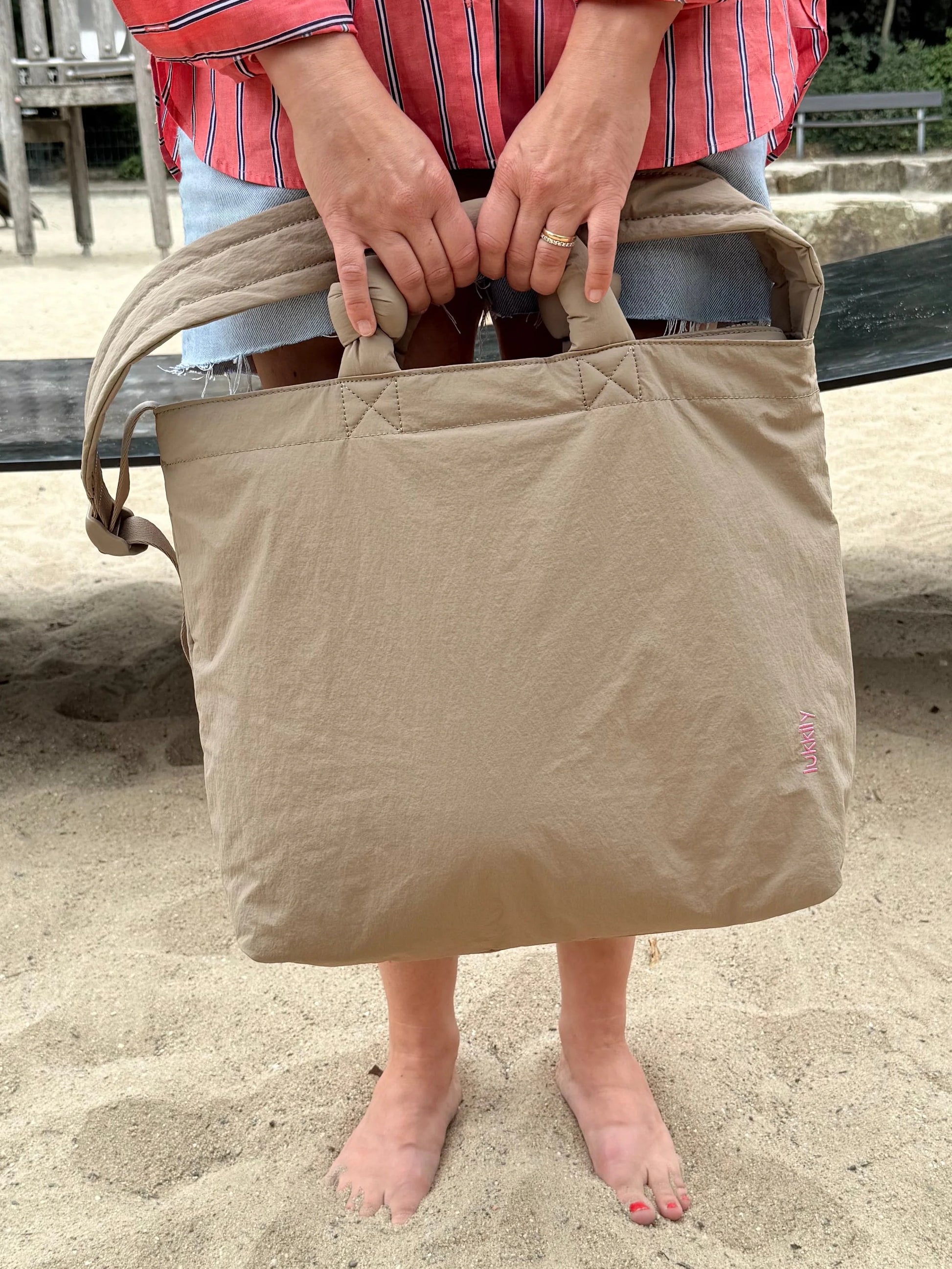 Beige Lukkily Tote Bag am kurzen Henkel getragen
