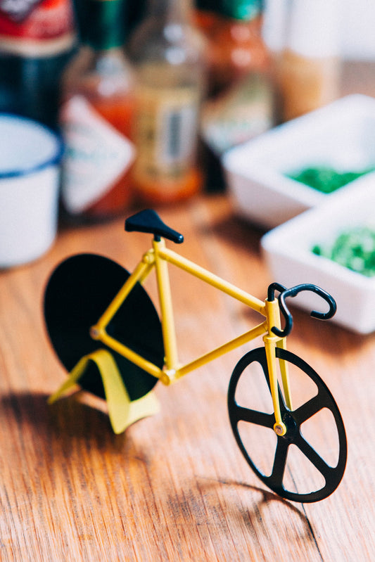 Fixie-Pizzaschneider in Fahrradform auf einem gedeckten Tisch