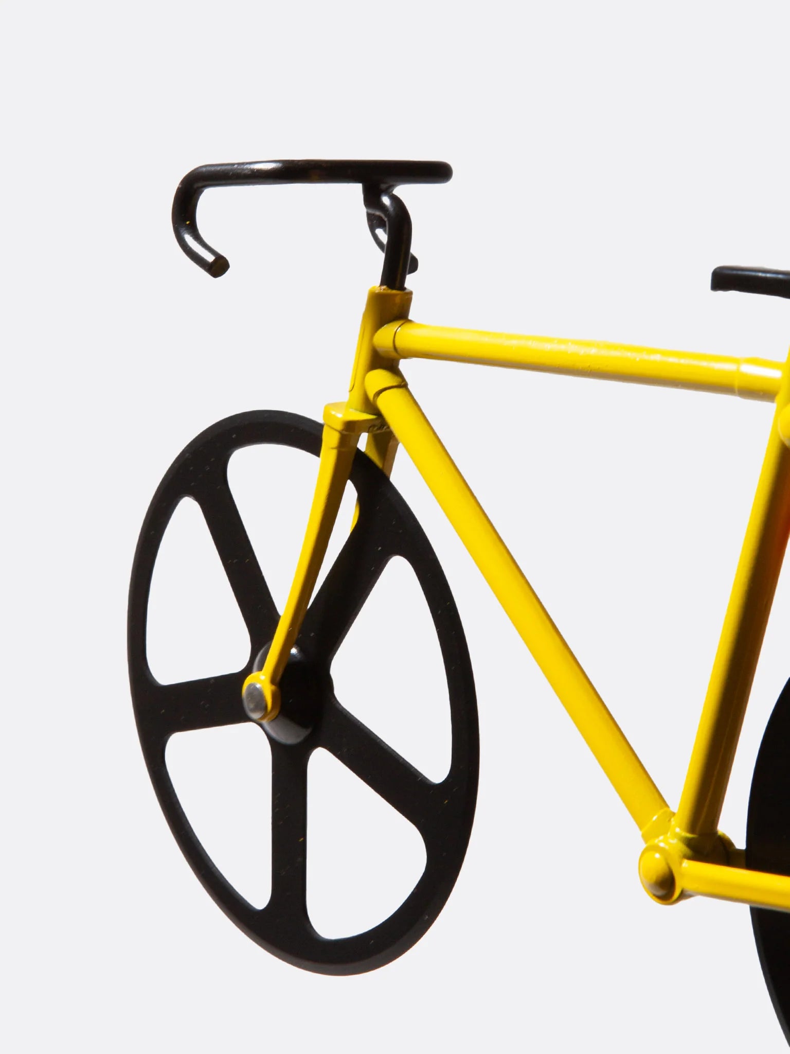 Detailansicht des gelben Fixie-Pizzaschneiders mit schwarzen Rädern