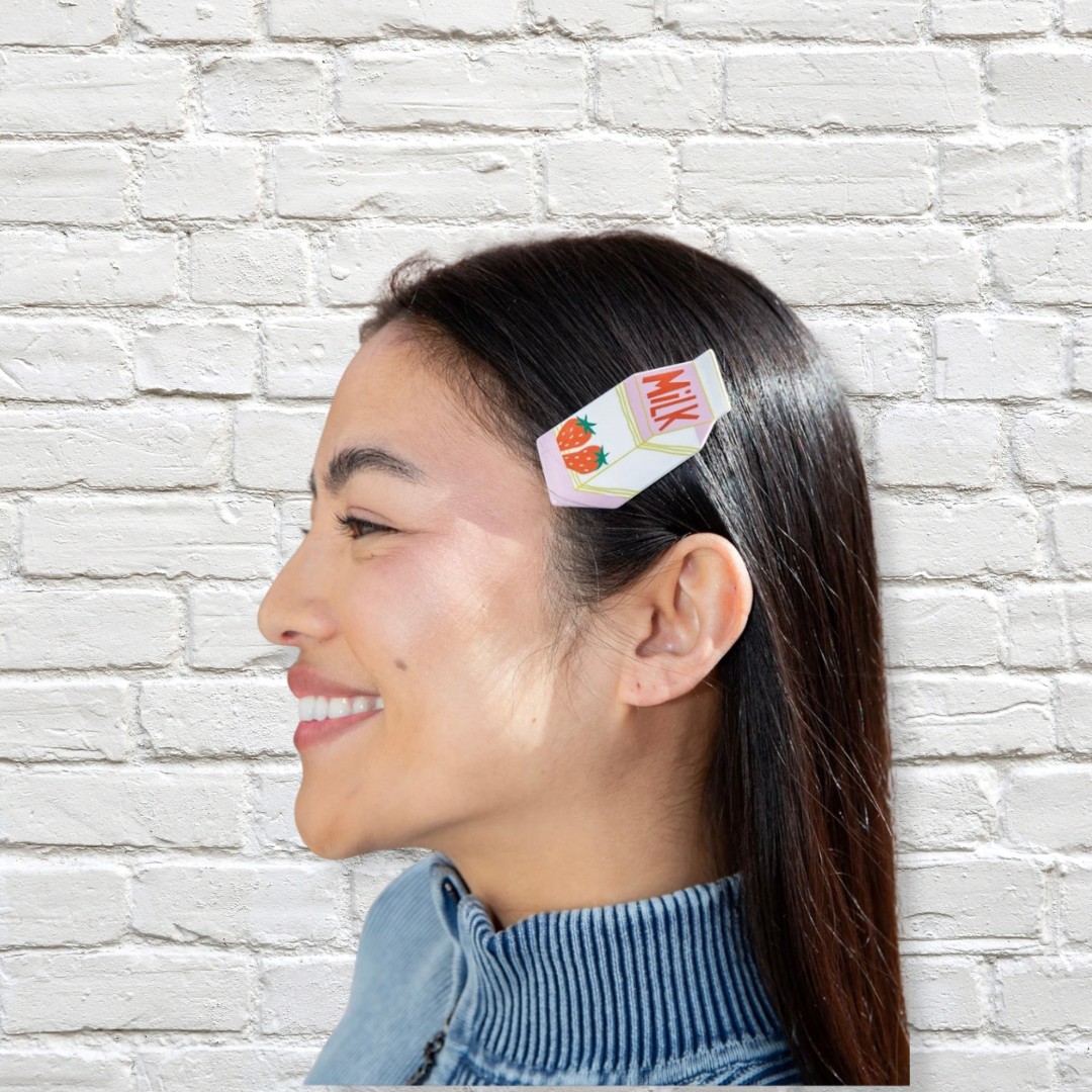 Weiße-Rosa Haarspange von Eat My Socks mit Milk-Motiv im dunklen Haar