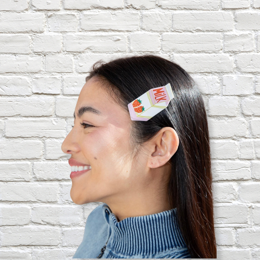 Weiße-Rosa Haarspange von Eat My Socks mit Milk-Motiv im dunklen Haar