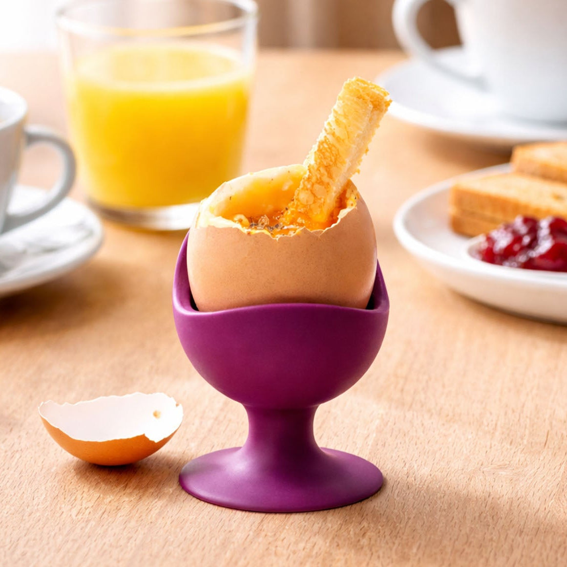 EggChair Eierbecher in Aubergine auf einem gedeckten Frühstückstisch