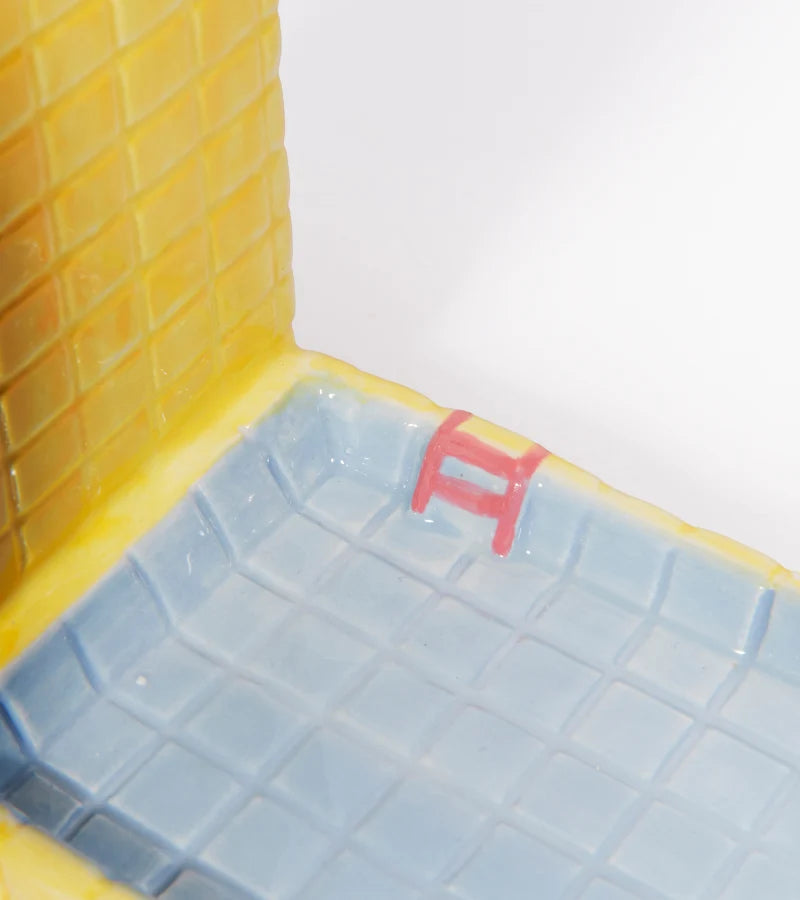 Detailansicht der blauen Pool-Ablage mit kleiner rosa Leiter