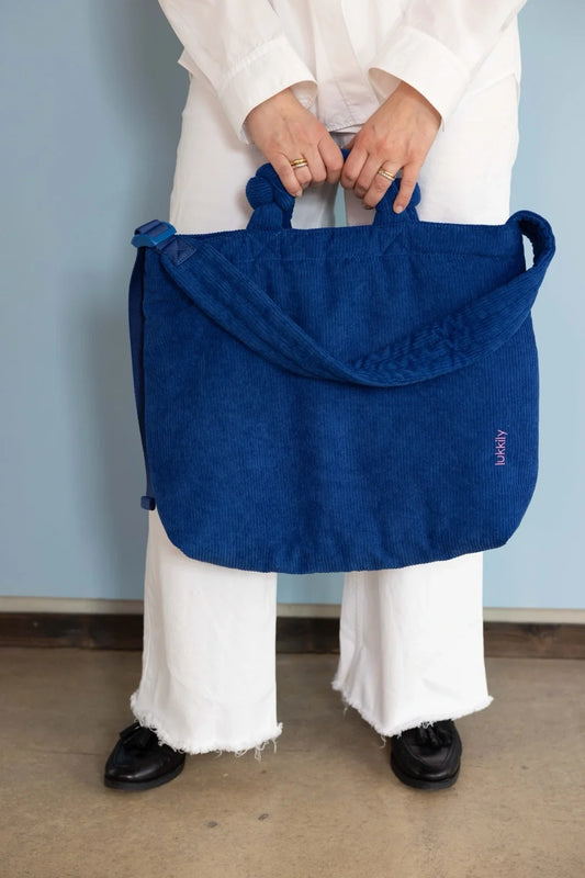 Blaue Lukkily Tote Bag Cord am kurzen Henkel getragen