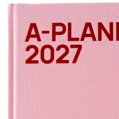 Detailansicht des rosafarbenen Leineneinbands mit roter Aufschrift „A-Planner 2027“