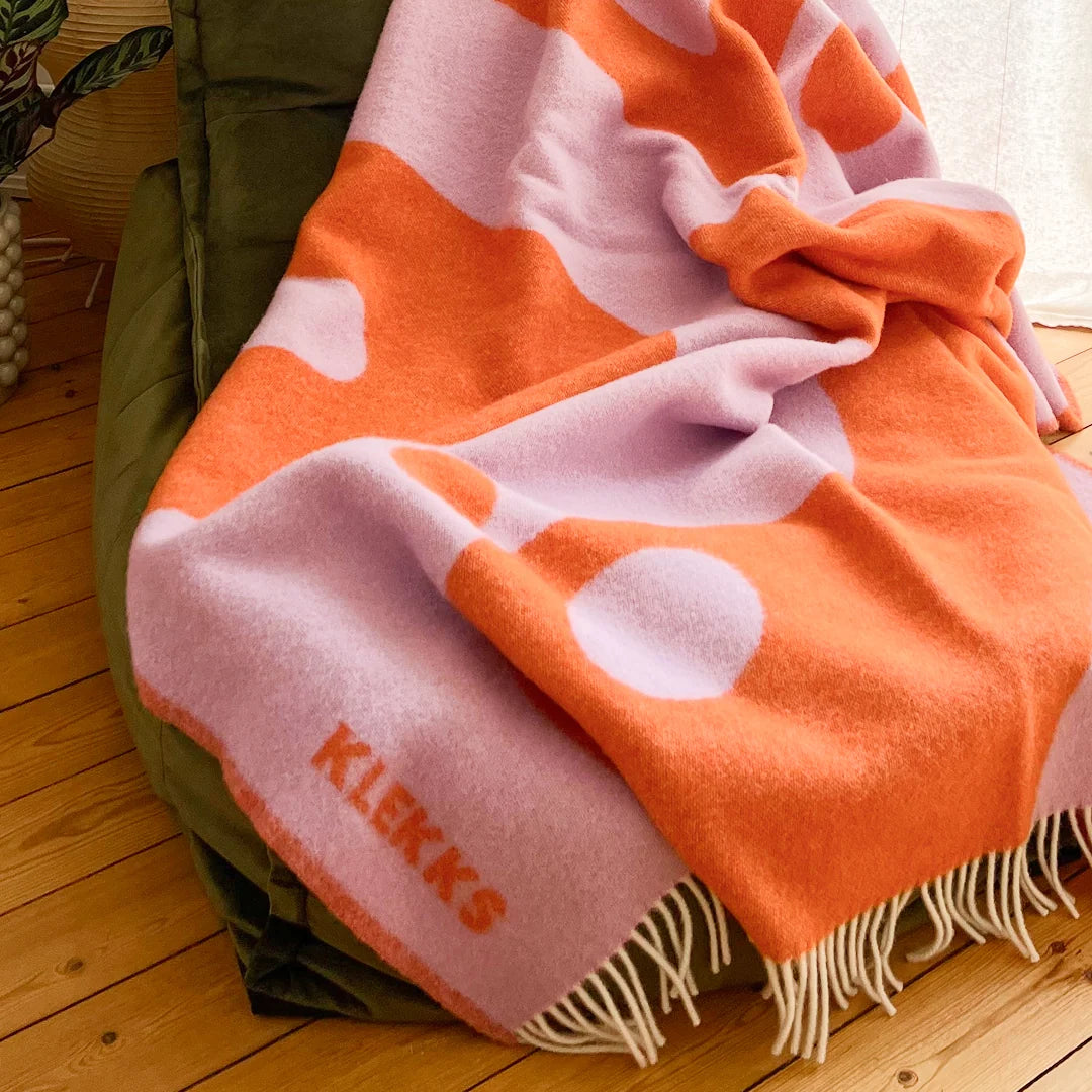 Orange-lilafarbene Klekks Decke No. 8 lässig über einem Sessel