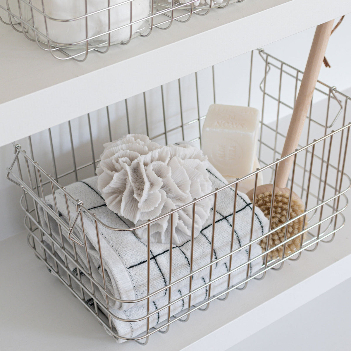Chromfarbener Metallkorb „Wire Basket Medium“ von Mette Ditmer als Aufbewahrungskorb im Badezimmer.